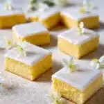 Freshly baked lemon blondies with a bright yellow color and a dusting of powdered sugar.